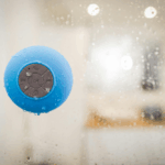 Portable water-resistant Bluetooth speaker placed near a poolside, showing its durability and waterproof