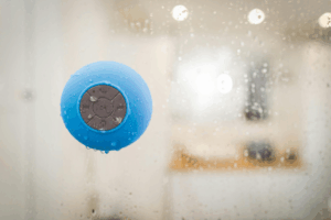 Portable water-resistant Bluetooth speaker placed near a poolside, showing its durability and waterproof